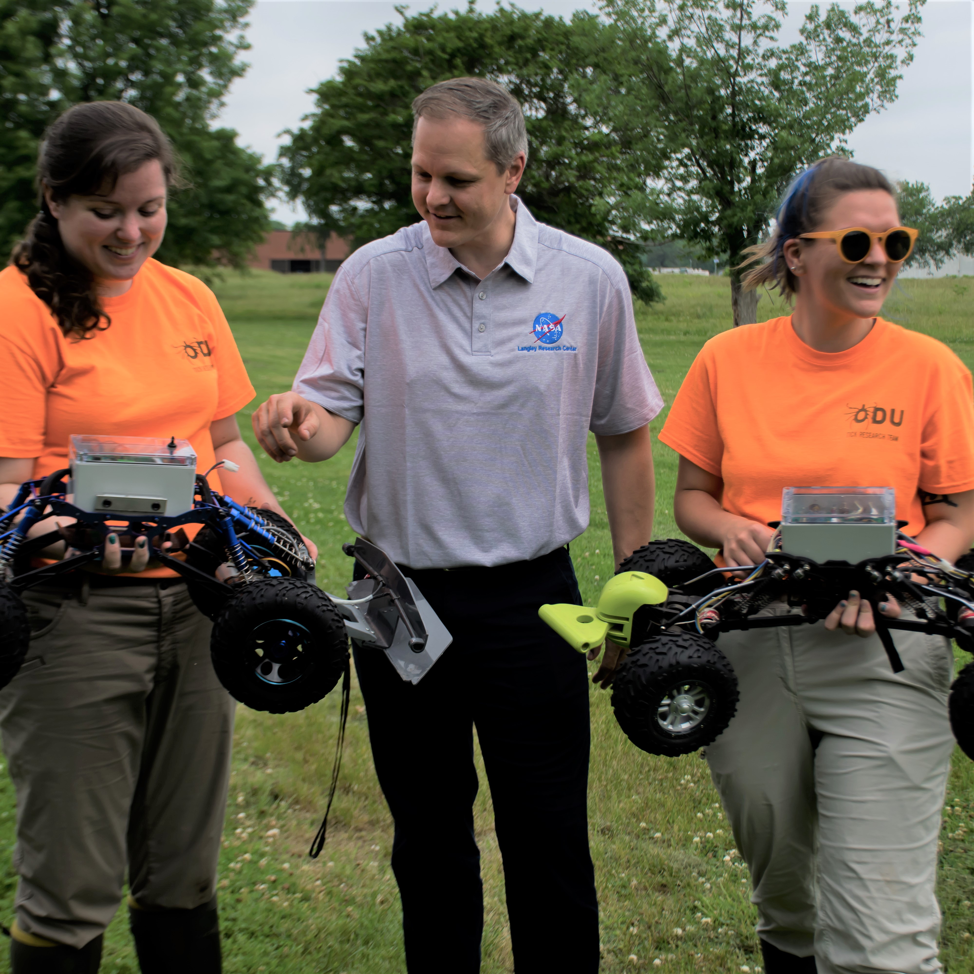 Old Dominion University students Alexis White, left, and Amanda DeVleeschower, right, are with NASA Langley environmental protection specialist Peter Van Dyke are pictured with 'TickBot' prototypes.